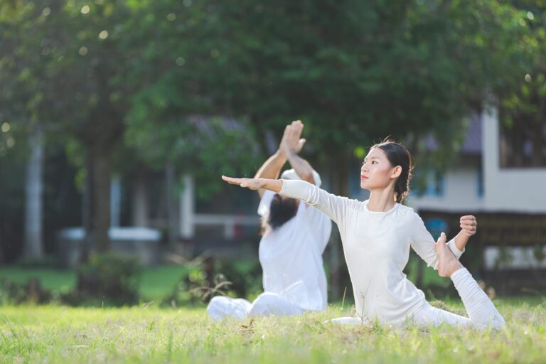 two-people-white-outfit-doing-yoga-nature-min